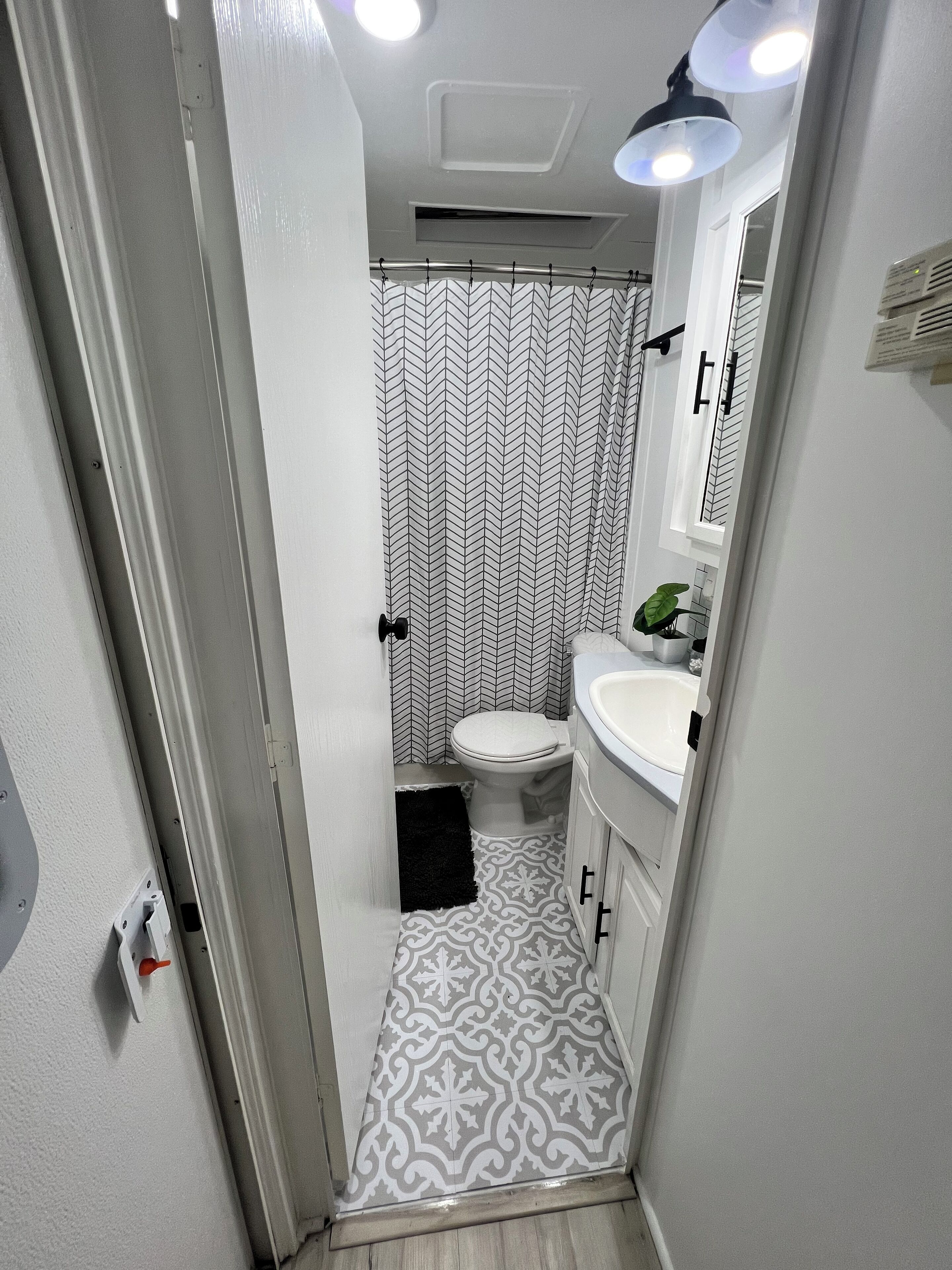 Un bagno con WC, lavandino e tenda doccia.