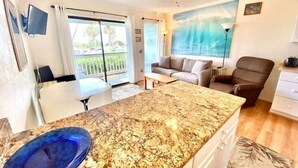 A room with a kitchen area, a dining table, a sofa, and a chair. - Oceanfront 1st Floor Condo, Unit 130!! Community Pool & Fishing Pier! Iin the Heart of IOP! (Isle of Palms)