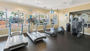 Gimnasio con cintas de correr, elípticas y equipo de pesas.