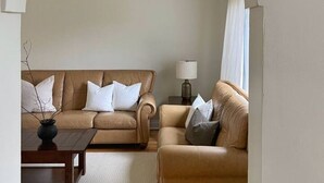 Een woonkamer met twee banken, een salontafel en een lamp.
