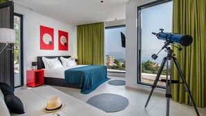 A modern hotel room with a large bed, a telescope, and a view of the city. - Villa Zvizdan - authentic local experience (Makarska)