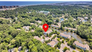 An aerial view of a residential area with a river, dense greenery, and a coastal cityscape in the background. - Family Friendly Lakeview Upper Vista in Sea Colony West (Bethany Beach)