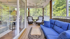 A covered porch with wicker furniture, a wooden table, and a ceiling fan. - Family Friendly Lakeview Upper Vista in Sea Colony West (Bethany Beach)