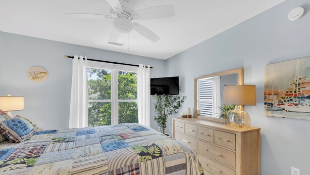 A bedroom with a bed, a ceiling fan, a dresser, a television, and a window with curtains. - Family Friendly Lakeview Upper Vista in Sea Colony West (Bethany Beach)