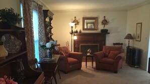 A living room with two armchairs, a fireplace, a table with a vase of flowers, and a bookshelf. - Yadkin Valley has the same viticulture stamp as NAPA.  Canoes and Kayaks!! (Elkin)