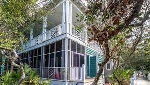 A two-story house with a balcony, surrounded by trees and plants. - In Seaside – Nearby Pool & Beach – Emma Lou (Seaside)