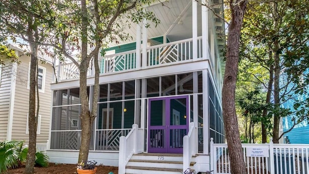 A two-story house with a porch, a purple door, and a white fence. - In Seaside – Nearby Pool & Beach – Emma Lou (Seaside)