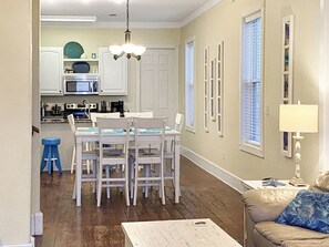 A compact living space with a dining area, kitchen, and a sofa.