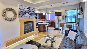 A modern living room with a fireplace, a dining area, and a kitchen in the background. - Rooftop Retreat-modern townhome in the heart of LoHi- roof deck-walk everywhere! (Denver)