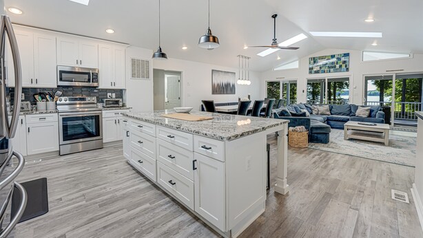 A modern kitchen with white cabinetry, a large island, and stainless steel appliances.