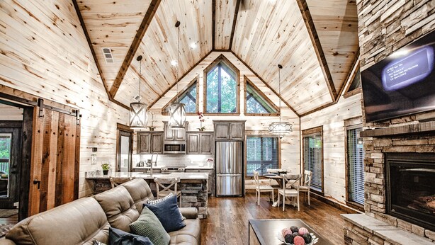 A log cabin interior with a dining area, kitchen, and living room. - Elegant Couples Cabin, Magnolia Design, 5-Star Amenities (Broken Bow)