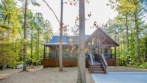 A cabin with a wooden deck and a staircase leading to a porch. - Elegant Couples Cabin, Magnolia Design, 5-Star Amenities (Broken Bow)