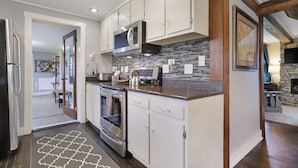 A modern kitchen with white cabinets, stainless steel appliances, and a patterned backsplash. - Near Whitetail, Berkeley Springs, Mercersburg, Hagerstown, Antietam, Frederick (Big Cove Tannery)