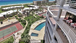 Ein Hotel mit Pool, Tennisplätzen und Blick auf den Strand.