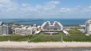 Ein Küstenhotel mit mehreren Gebäuden, einem Strand und Blick auf den Ozean sowie einen entfernten Steg.