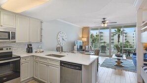 Una cocina moderna con armarios blancos, electrodomésticos de acero inoxidable y una isla grande.