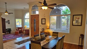 A dining area with a wooden table, chairs, and a chandelier. - Spacious 4BR Coyote Ranch Retreat with Private Pool & RV Parking in Casa Grande (Casa Grande)