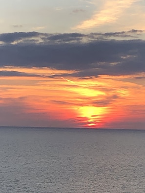 Ein Sonnenuntergang über einem ruhigen Meer mit klarem Horizont.