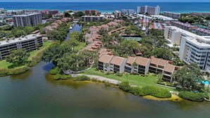 Ein Luftbild eines Küstenresorts mit mehreren Gebäuden, einer Marina und einem Fluss.