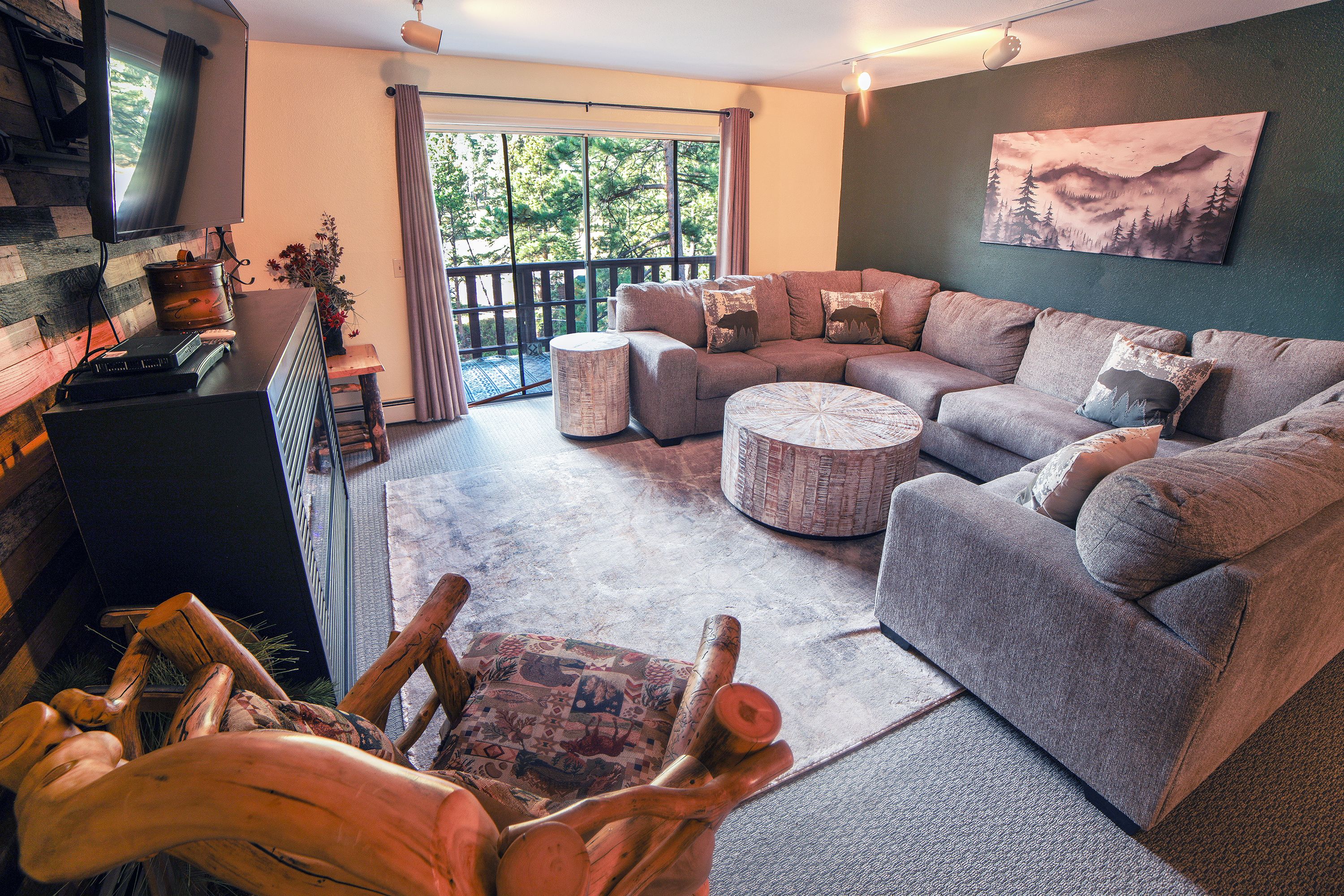 A modern living room with a sectional sofa, a coffee table, and a television on a wooden stand.