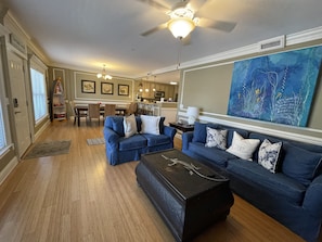 Relax in this stylish living room with a large sofa, ottoman, and dining area.