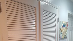 Un pasillo con dos puertas cerradas, una con ventana y la otra con un cartel.
