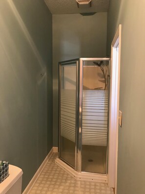 Een bad/douchecombinatie, een haardroger, handdoeken