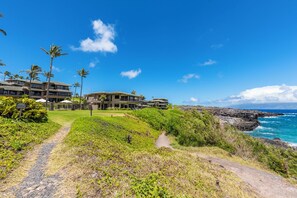 Um hotel à beira-mar com vários edifícios, um caminho que leva à praia e vista para o oceano.