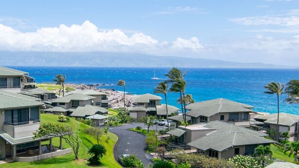 A coastal residential area with houses, a winding road, and a view of the ocean. - Kapalua Bay Villa 14B1 | Coastal Vibes & Ocean Views (Lahaina)