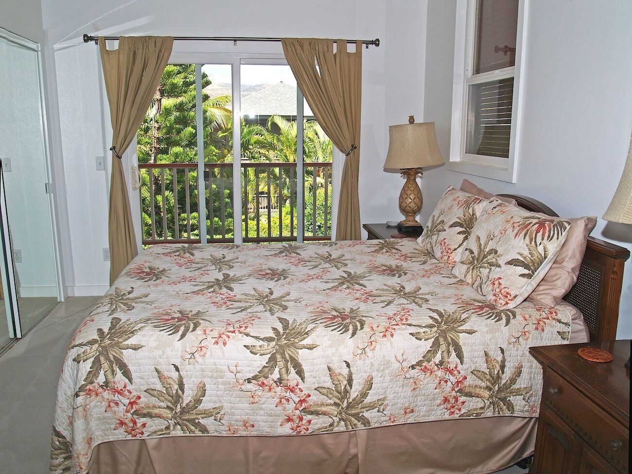 Un dormitorio con cama, cortinas, una mesita de noche, lámpara y vistas a zonas verdes.