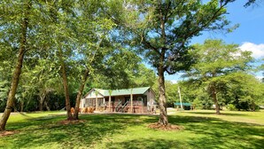 A house surrounded by trees with a porch and a covered deck. - River Front, Fishing, Kayaking, Boating, Tubing on the Edisto River   (Ridgeville)