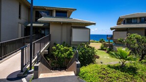 A beachfront hotel with a two-story structure, a covered outdoor area, and a view of the ocean. - Kapalua Bay Villa 35G4 | Sunset Views | Walk to Beach (Lahaina)