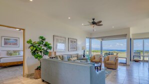 A spacious living area with a sofa, chairs, a large potted plant, and artwork on the walls. - Kapalua Bay Villa 35G4 | Sunset Views | Walk to Beach (Lahaina)