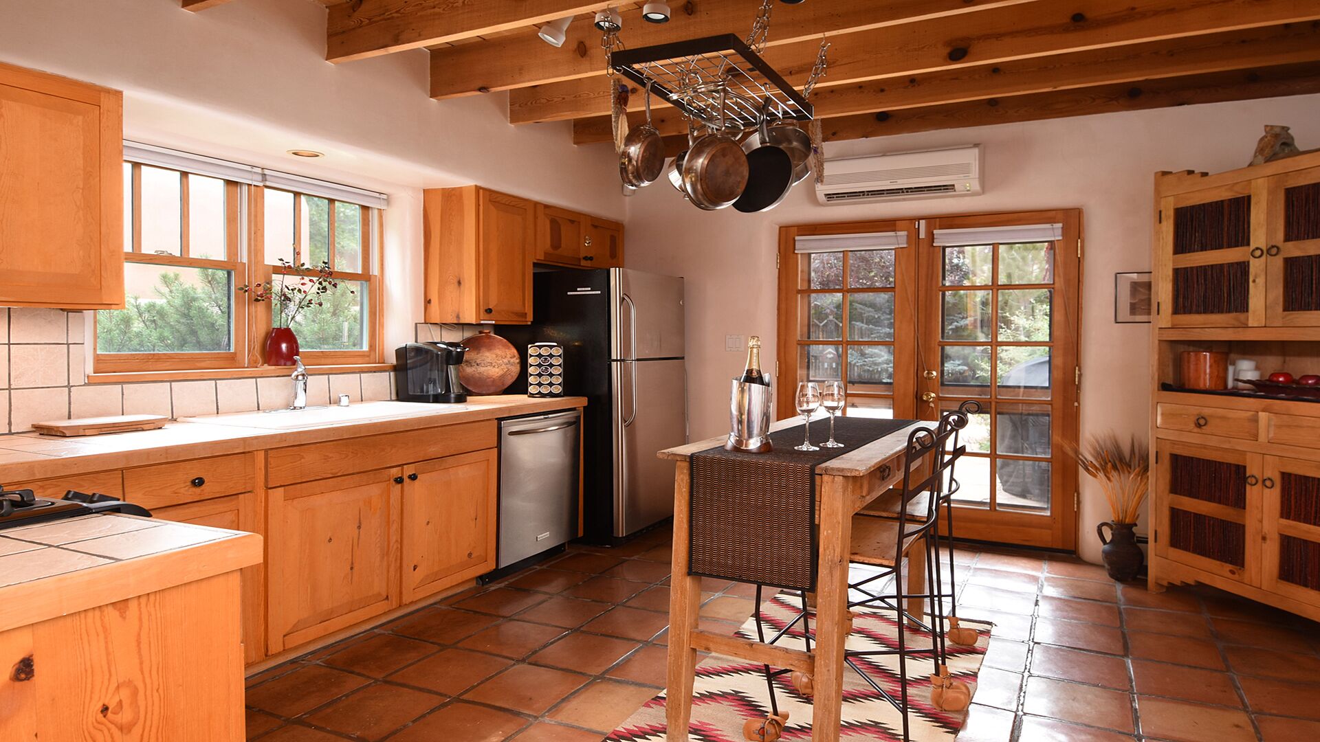 A kitchen with wooden cabinets, a refrigerator, a stove, and a dining area with a table and chairs.
