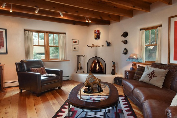 Our art-filled living room with Navajo rug, kiva fireplace and leather seating