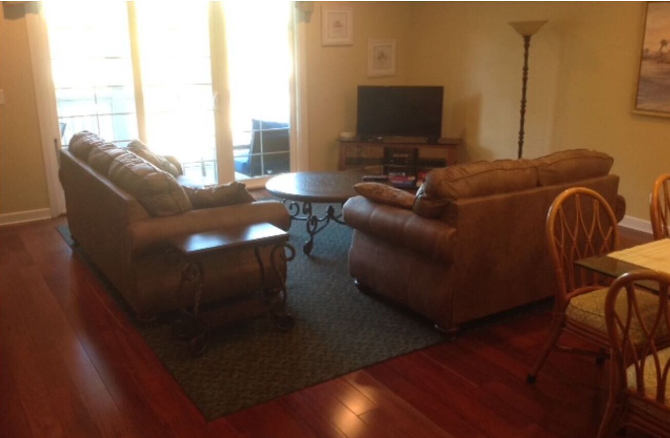 A living room with a sofa set, a coffee table, and a TV.