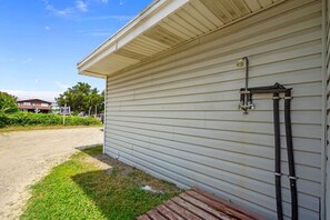 Situated on a gravel driveway, this single-story building features a light-colored exterior and a wooden boardwalk leading to the entrance.