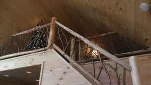 A wooden staircase with a handrail, leading to a loft area with a slanted ceiling. - ENJOY SUMMER IN THE ADIRONDACKS AT RUBY HILL CABINS (Wells)