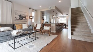 A modern living room with a sofa, chairs, a coffee table, and a staircase. - 
Townhome with Stunning Views & Modern Finishes (Missoula)