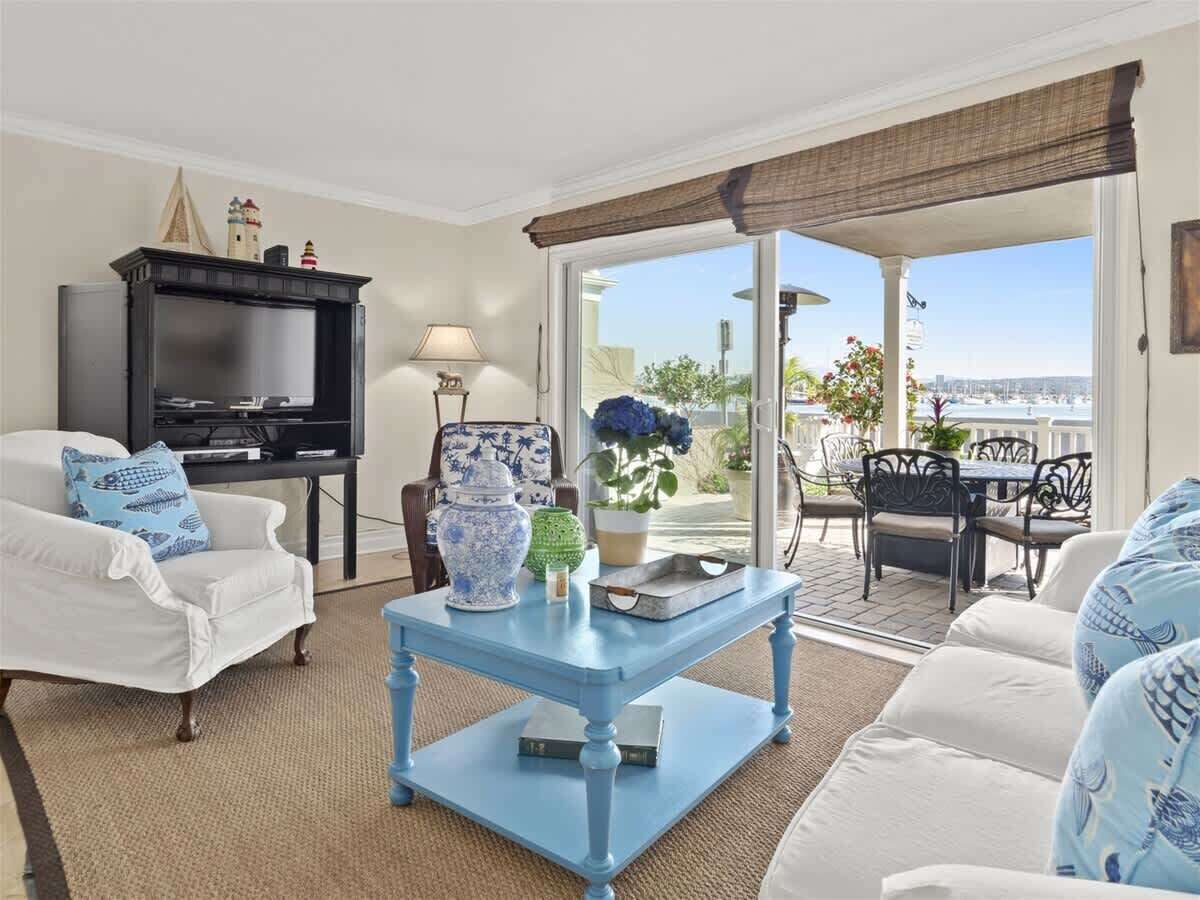 Un salon avec un téléviseur, une table basse et une vue sur l’extérieur.