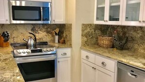 A kitchen with white cabinets, a stainless steel stove, a microwave, and a dishwasher.