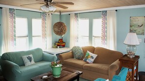 A living room with two sofas, a coffee table, a lamp, and a ceiling fan. - Island Serenity- Island Time Up in Old Town  (Port Aransas)