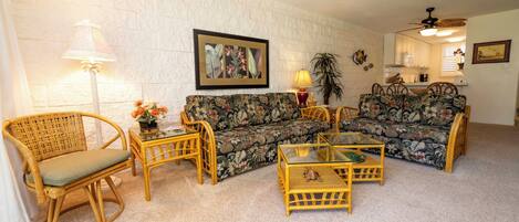 A living room with a sofa, two armchairs, a coffee table, and a lamp.