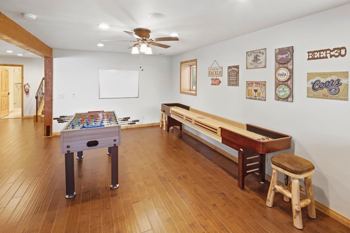 Una habitación con mesa de futbolín, mesa de billar y un banco.