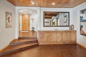 Eine Holztreppe führt zu einem Raum mit einem großen Spiegel und einem Holzschrank.