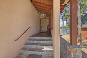 Una escalera de piedra que lleva a una puerta de madera con una estatua de oso en el exterior.