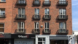 Un edificio in mattoni di più piani con un negozio che si chiama "Hollywood Nail".