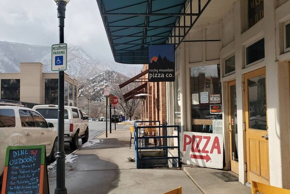 A restaurant with a sign for 'PIZZA CO.' and a 'RESERVED PARKING' sign nearby.