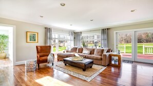 A spacious living room with hardwood flooring, a leather armchair, a sofa set, and a large window offering a view of a green landscape. - Location!!! Location!!! Berkshire Glamour (and comfort) Meets Town And Country (Stockbridge)