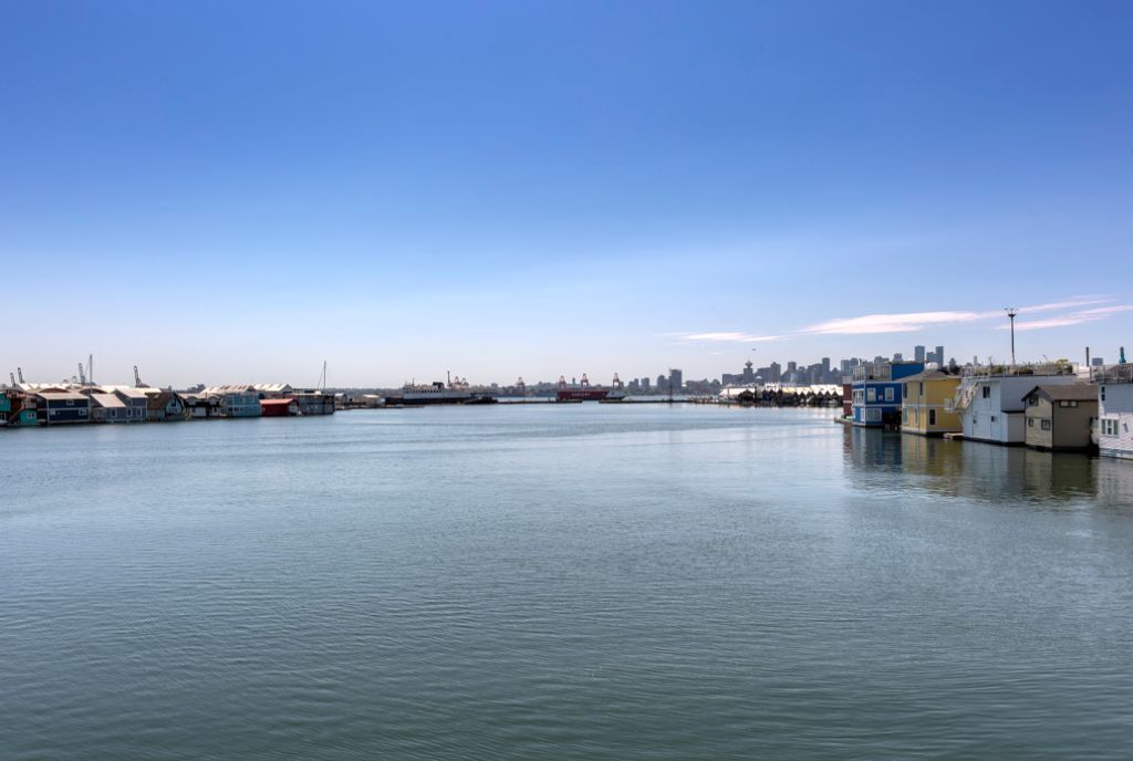 Une vue sur le front de mer, avec des bâtiments, un quai et un ciel dégagé.